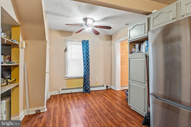 kitchen with stainless steel refrigerator, ceiling fan, dark hardwood / wood-style floors, a textured ceiling, and a baseboard radiator