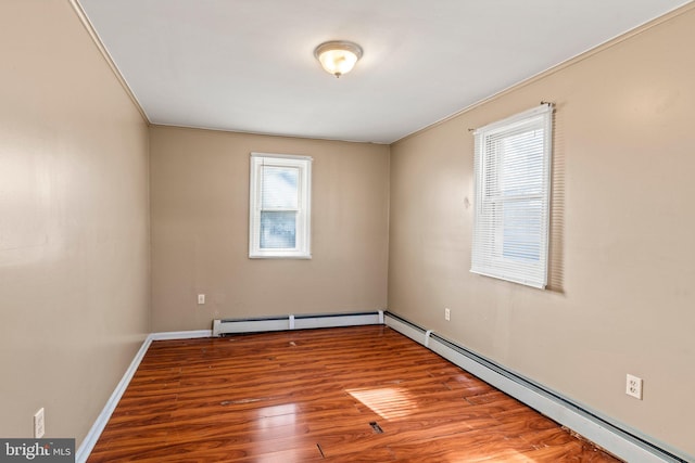 unfurnished room featuring a baseboard heating unit, plenty of natural light, and wood-type flooring