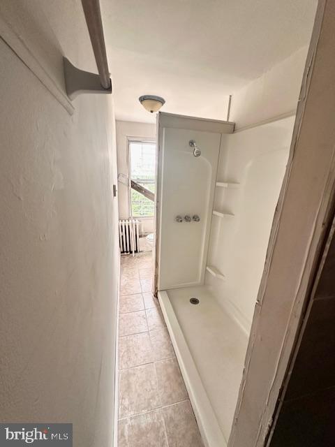 bathroom featuring walk in shower and tile patterned floors