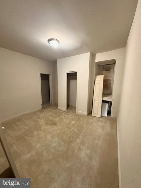 unfurnished bedroom with light colored carpet and baseboards