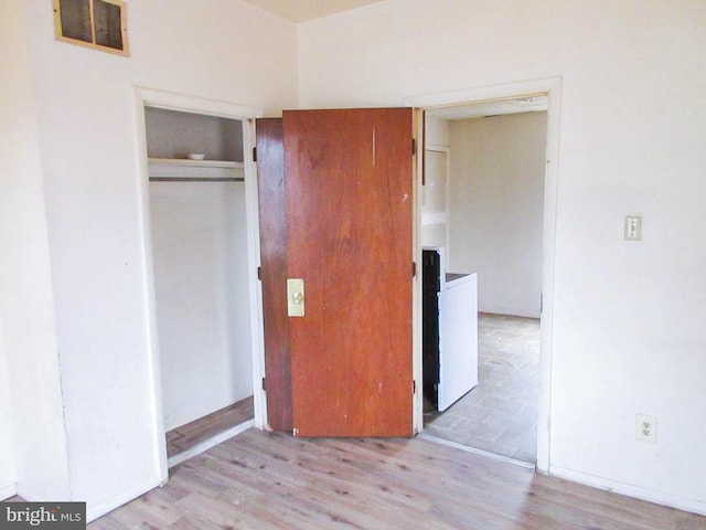 unfurnished bedroom featuring a closet and light wood-type flooring