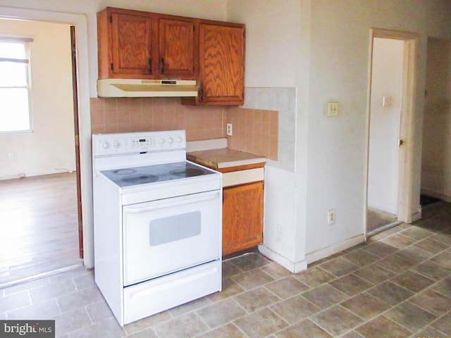 kitchen with tasteful backsplash and white range with electric stovetop