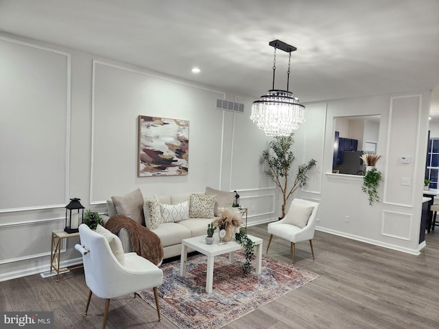 living room with an inviting chandelier and hardwood / wood-style floors