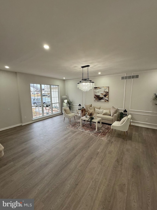 living room with a notable chandelier and dark wood-type flooring