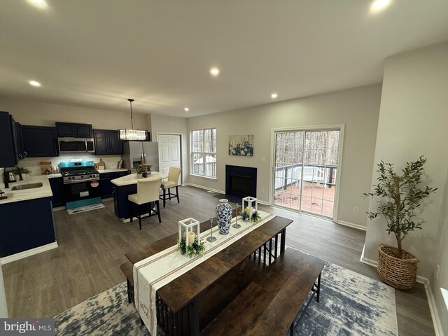 living room featuring dark wood-type flooring, plenty of natural light, and sink