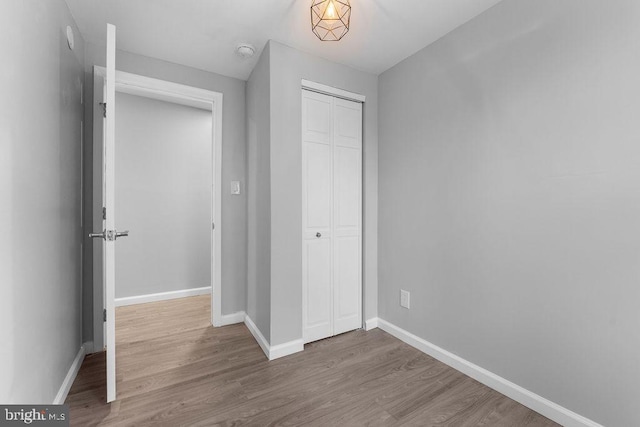 unfurnished bedroom featuring hardwood / wood-style flooring and a closet