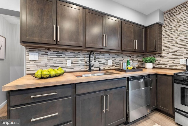 kitchen featuring butcher block countertops, sink, appliances with stainless steel finishes, dark brown cabinetry, and decorative backsplash