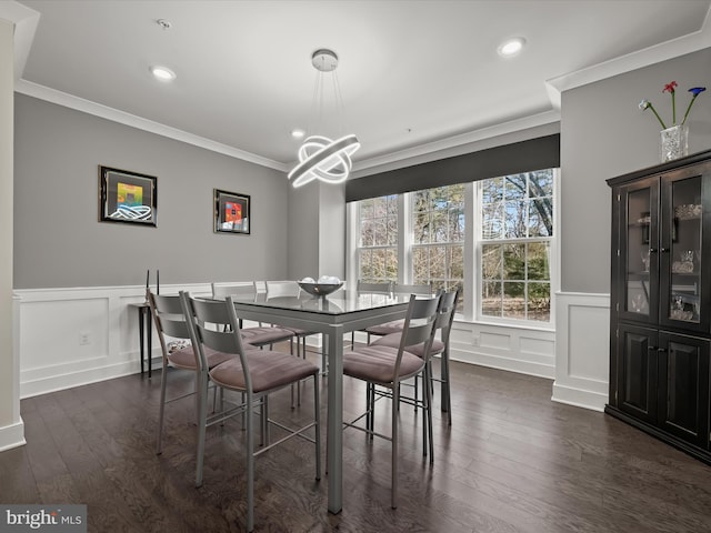 dining room featuring a notable chandelier, dark wood-style floors, crown molding, and a decorative wall