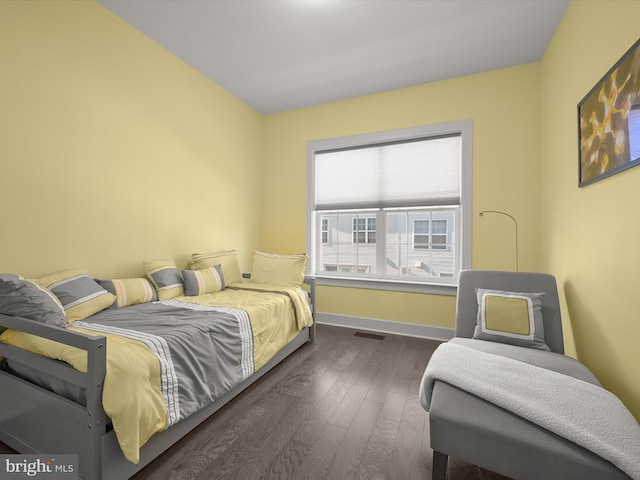 bedroom featuring dark wood finished floors, visible vents, and baseboards