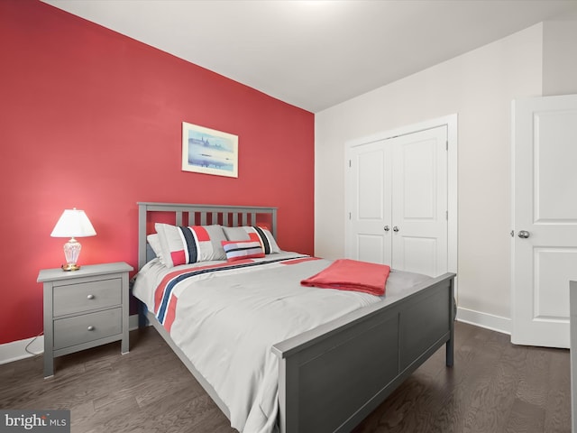 bedroom featuring a closet, baseboards, and dark wood-style floors