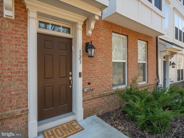 doorway to property featuring brick siding