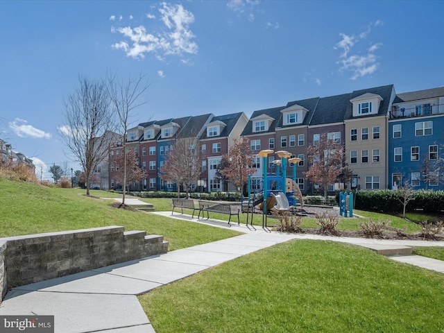 view of community featuring playground community, a lawn, and a residential view