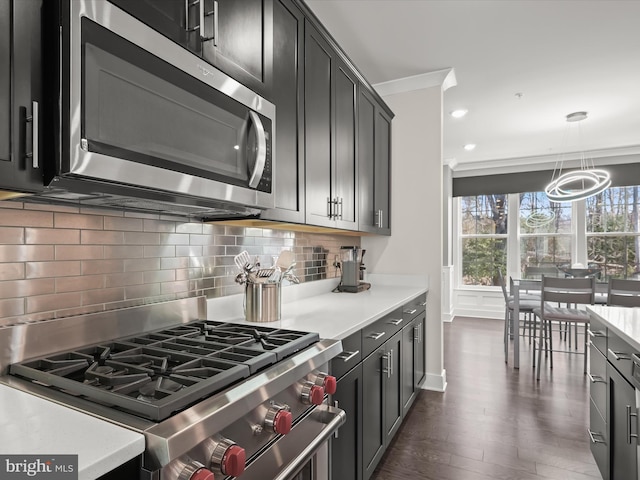 kitchen with decorative backsplash, appliances with stainless steel finishes, ornamental molding, and light countertops