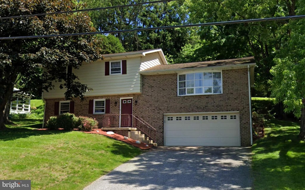 tri-level home featuring a garage and a front lawn