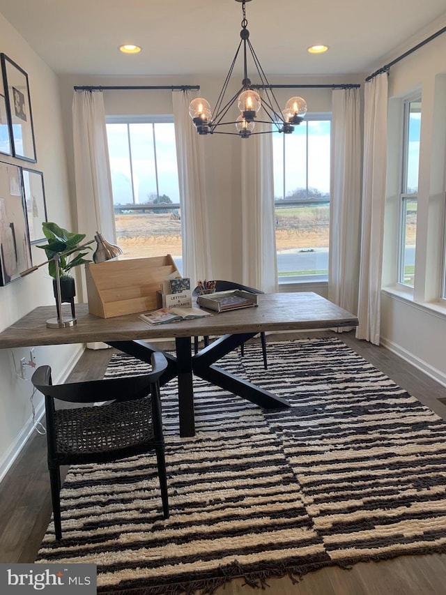 dining space with dark wood-type flooring and an inviting chandelier