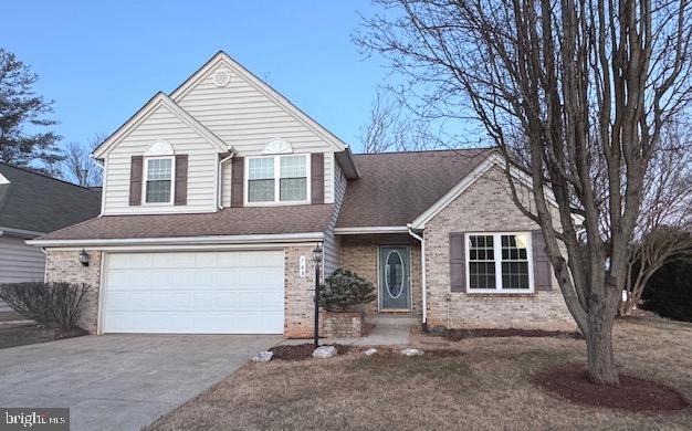 view of front of property with a garage, concrete driveway, and brick siding