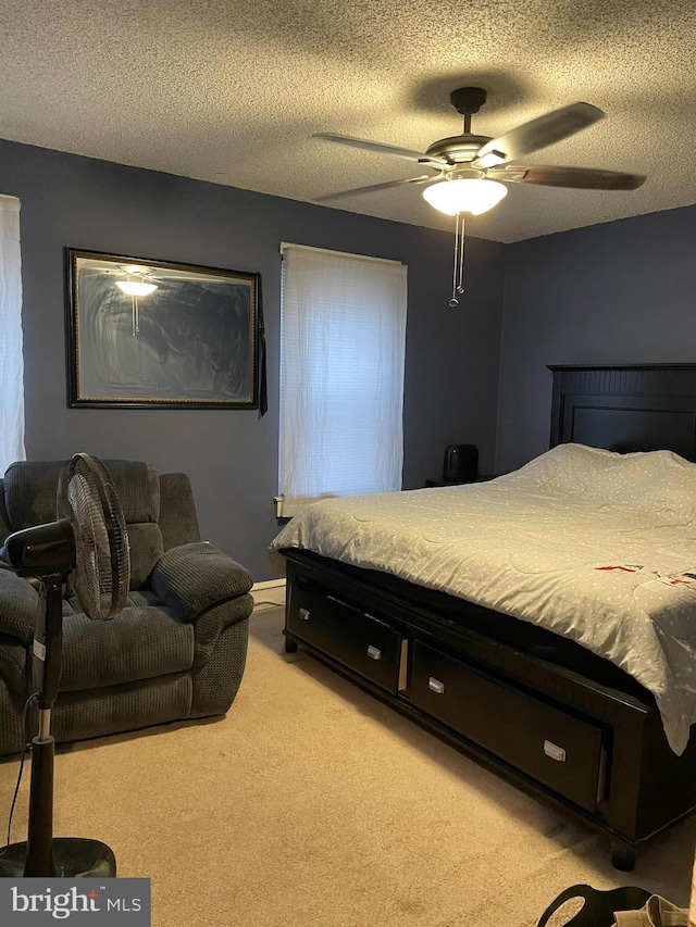 carpeted bedroom with a ceiling fan and a textured ceiling