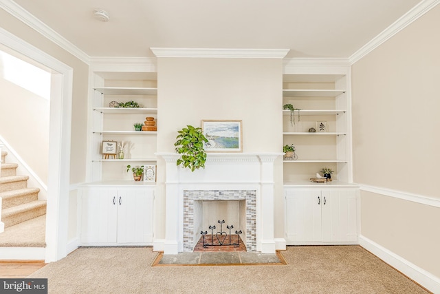 room details with a tiled fireplace, ornamental molding, built in features, and carpet flooring