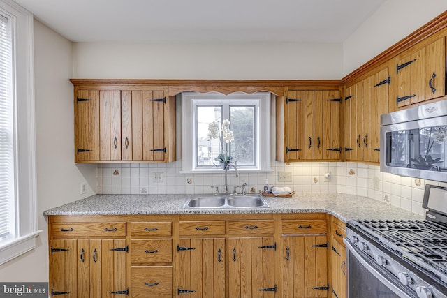 kitchen with tasteful backsplash, appliances with stainless steel finishes, and sink