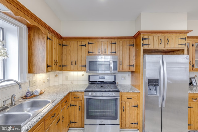 kitchen with appliances with stainless steel finishes, sink, and decorative backsplash