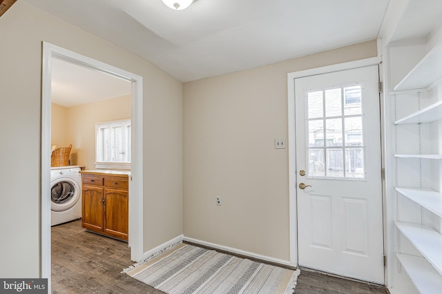 doorway to outside with dark hardwood / wood-style flooring and washer / dryer