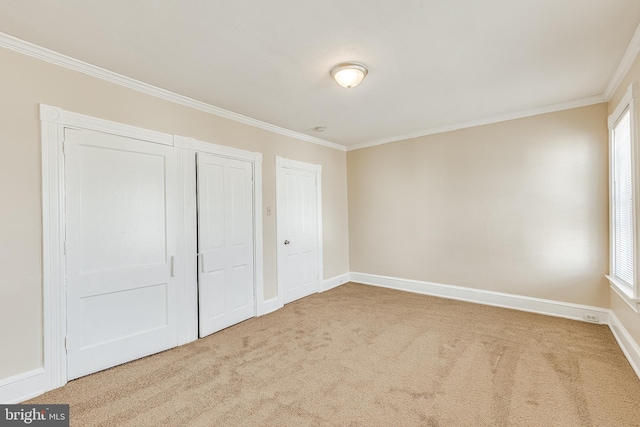 unfurnished bedroom featuring multiple windows, crown molding, and carpet floors