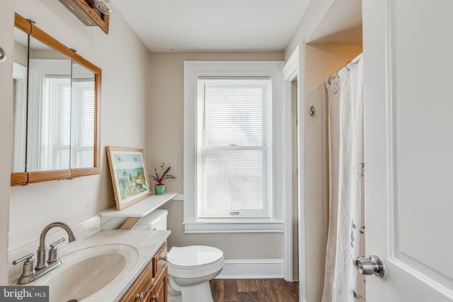 bathroom featuring vanity, wood-type flooring, a wealth of natural light, and toilet