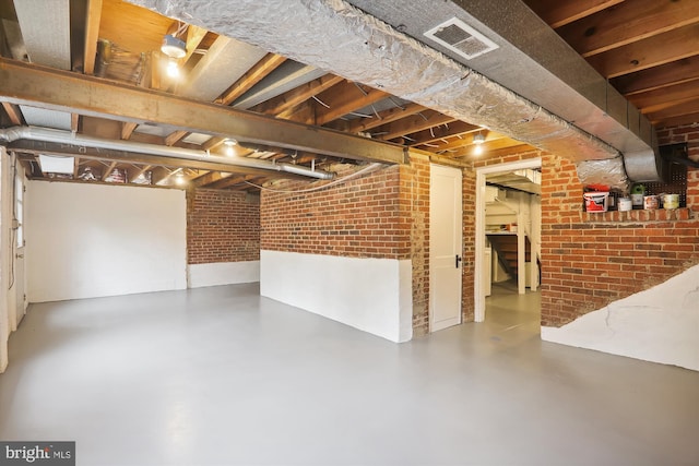 basement featuring brick wall