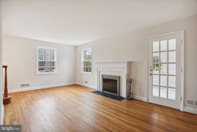 unfurnished living room featuring a fireplace and light wood-type flooring