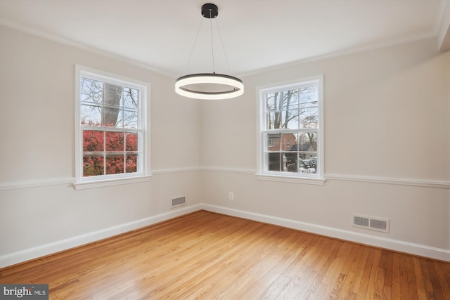 empty room featuring light hardwood / wood-style flooring and ornamental molding