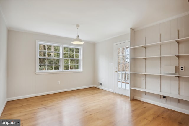 spare room with hardwood / wood-style floors and crown molding