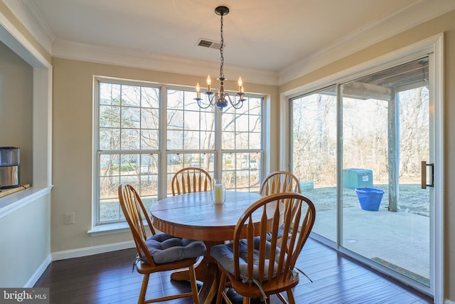 dining space with a chandelier, hardwood / wood-style flooring, visible vents, baseboards, and ornamental molding