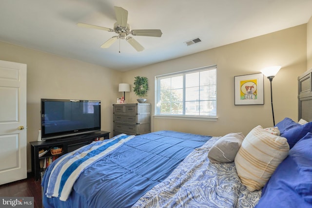 bedroom featuring visible vents, dark wood finished floors, and ceiling fan