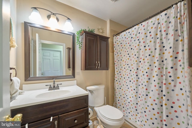 full bath with a shower with curtain, vanity, and toilet