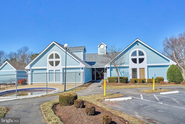 view of property featuring uncovered parking and fence