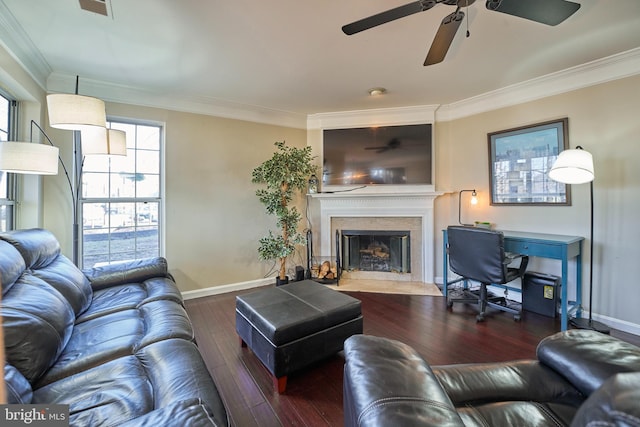 living area featuring a fireplace with raised hearth, wood finished floors, visible vents, baseboards, and crown molding