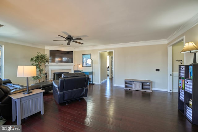 living room featuring dark wood-style flooring, a fireplace, and crown molding