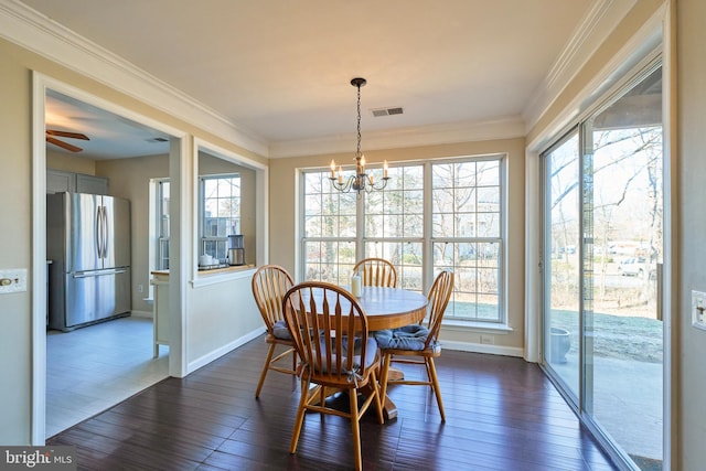 dining room featuring dark wood-style floors, ornamental molding, and a wealth of natural light