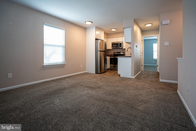 kitchen with white cabinetry, carpet floors, and stainless steel appliances