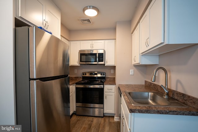 kitchen featuring white cabinetry, appliances with stainless steel finishes, sink, and dark wood-type flooring