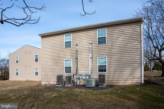 back of property featuring a yard and central AC unit