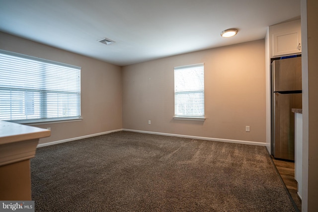 carpeted empty room featuring plenty of natural light