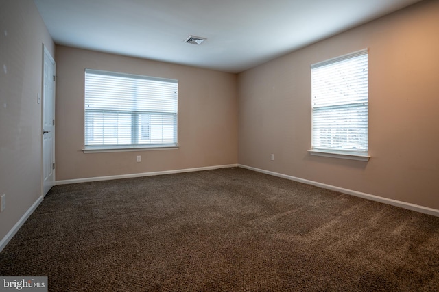 carpeted spare room featuring a wealth of natural light