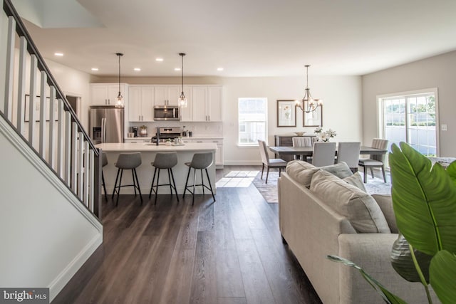 living room featuring sink, a notable chandelier, and dark hardwood / wood-style floors