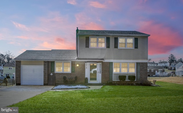 view of property featuring a garage and a lawn