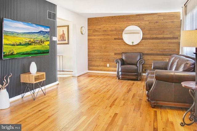 living room featuring wooden walls and light hardwood / wood-style flooring