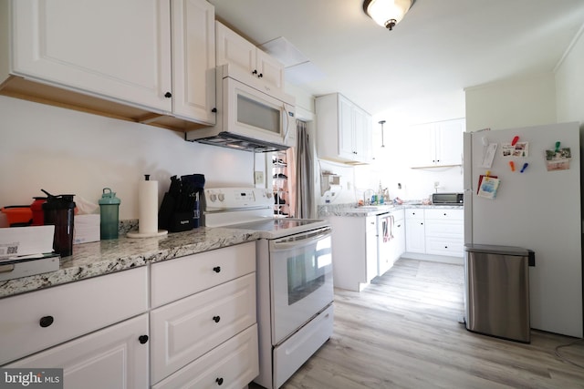 kitchen with sink, light stone counters, light hardwood / wood-style flooring, white appliances, and white cabinets