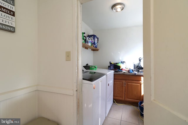 clothes washing area with washer and clothes dryer and light tile patterned floors