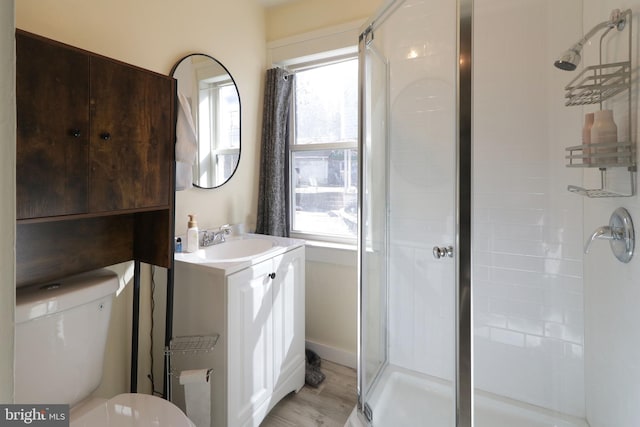 bathroom with walk in shower, vanity, and toilet