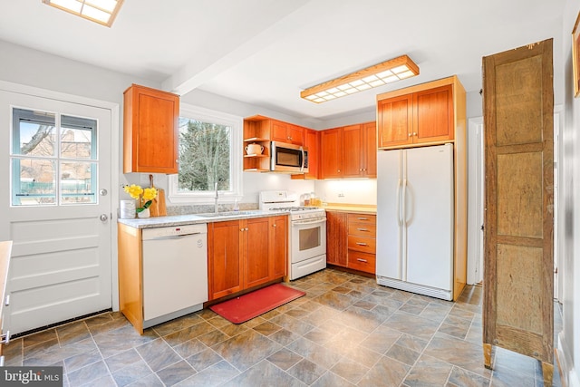 kitchen featuring beam ceiling, sink, and white appliances